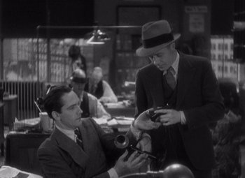 Movie still from “Merrily We Go to Hell” (1932), directed by Dorothy Arzner – A man in a suit and a hat is holding a camera; Medium shot, High angle