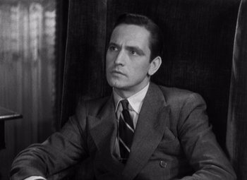 Movie still from “Merrily We Go to Hell” (1932), directed by Dorothy Arzner – Black and white photograph of a man wearing a suit and tie; Close Up shot, Low angle