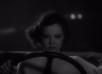 Movie still from “Merrily We Go to Hell” (1932), directed by Dorothy Arzner – A black and white photo of a woman driving a car; Close Up shot, High angle