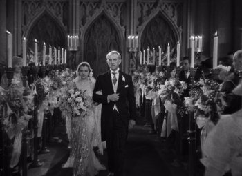 Movie still from “Merrily We Go to Hell” (1932), directed by Dorothy Arzner – A man and a woman walking down the aisle of a church; Wide shot, High angle
