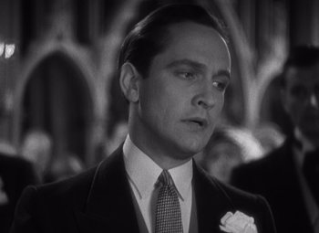 Movie still from “Merrily We Go to Hell” (1932), directed by Dorothy Arzner – A black and white photo of a man in a suit and tie; Close Up shot, Low angle