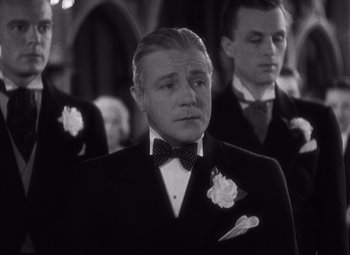 Movie still from “Merrily We Go to Hell” (1932), directed by Dorothy Arzner – Black and white photograph of a man in a suit and bow tie; Close Up shot, Low angle