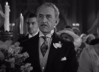 Movie still from “Merrily We Go to Hell” (1932), directed by Dorothy Arzner – An older man in a suit holding a bouquet of flowers; Close Up shot, Low angle