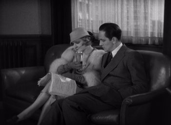 Movie still from “Merrily We Go to Hell” (1932), directed by Dorothy Arzner – A man and a woman sitting on a couch; Medium shot, High angle