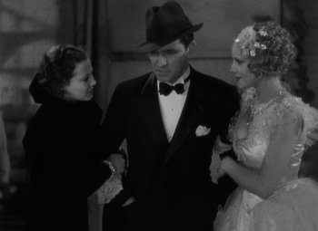 Movie still from “Merrily We Go to Hell” (1932), directed by Dorothy Arzner – A man and two women standing next to each other in front of a building; Medium shot, High angle