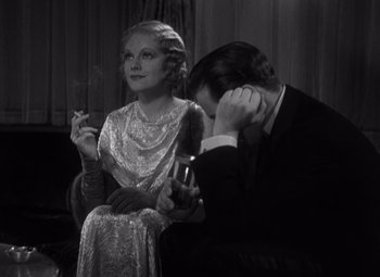 Movie still from “Merrily We Go to Hell” (1932), directed by Dorothy Arzner – An old photo of a man and a woman smoking; Medium shot, High angle