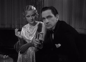 Movie still from “Merrily We Go to Hell” (1932), directed by Dorothy Arzner – A man and a woman pose for a picture; Medium shot, Low angle