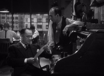 Movie still from “Merrily We Go to Hell” (1932), directed by Dorothy Arzner – Two men in suits and ties working on a film set; Medium shot, Over the shoulder angle
