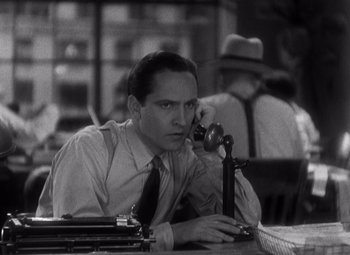 Movie still from “Merrily We Go to Hell” (1932), directed by Dorothy Arzner – A black and white photo of a man sitting at a table; Close Up shot, High angle