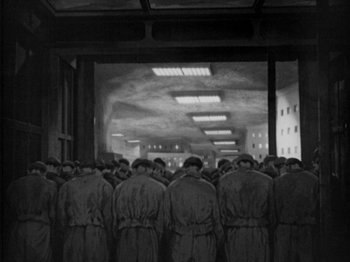 Movie still from “Metropolis” (1927), directed by Fritz Lang – Black and white photograph of a group of men in uniforms; Extreme Wide shot, High angle