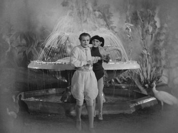 Movie still from “Metropolis” (1927), directed by Fritz Lang – A man and a woman standing in front of a fountain; Wide shot, High angle