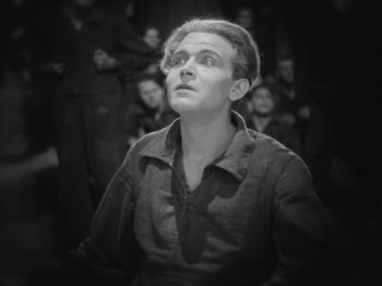 Movie still from “Metropolis” (1927), directed by Fritz Lang – A man looking up at a crowd of people in the background; Close Up shot, High angle