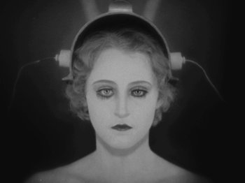 Movie still from “Metropolis” (1927), directed by Fritz Lang – A black and white photo of a woman with headphones on her head; Close Up shot, High angle