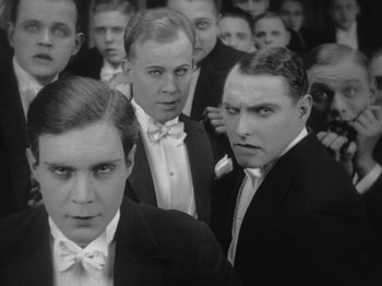 Movie still from “Metropolis” (1927), directed by Fritz Lang – A group of men in suits posing for a picture; Medium shot, Low angle