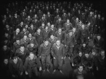 Movie still from “Metropolis” (1927), directed by Fritz Lang – A large group of men standing in a room together; Extreme Wide shot, High angle