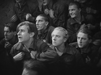 Movie still from “Metropolis” (1927), directed by Fritz Lang – A black and white photo of a group of men; Medium shot, High angle