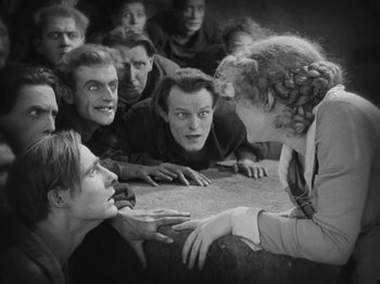 Movie still from “Metropolis” (1927), directed by Fritz Lang – A group of people sitting around each other in a room; Medium shot, High angle