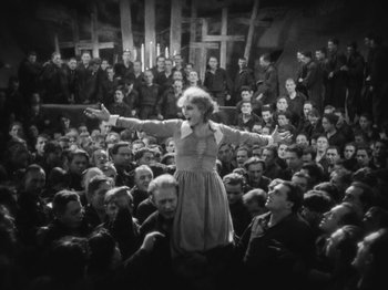 Movie still from “Metropolis” (1927), directed by Fritz Lang – An old photo of a woman singing in front of a crowd; Wide shot, High angle