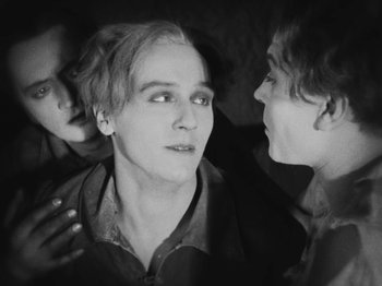 Movie still from “Metropolis” (1927), directed by Fritz Lang – A black - and - white photo of a man and two other men; Close Up shot, High angle