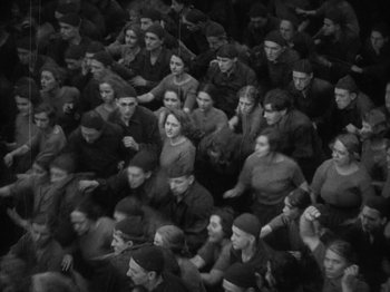 Movie still from “Metropolis” (1927), directed by Fritz Lang – A large group of people sitting in a room together; Extreme Wide shot, High angle