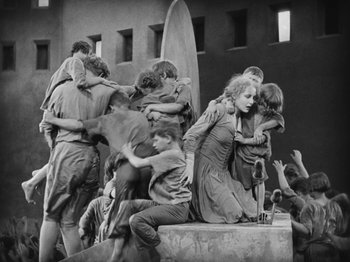Movie still from “Metropolis” (1927), directed by Fritz Lang – A group of people sitting on top of a building; Wide shot, High angle
