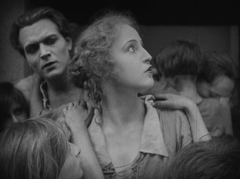Movie still from “Metropolis” (1927), directed by Fritz Lang – An old photo of a man and a woman looking up; Medium shot, Low angle