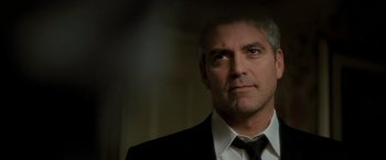 Movie still from “Michael Clayton” (2007), directed by Tony Gilroy – A person wearing a suit and tie; Close Up shot, Low angle