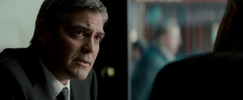 Movie still from “Michael Clayton” (2007), directed by Tony Gilroy – A person wearing a suit and tie; Close Up shot, Over the shoulder angle