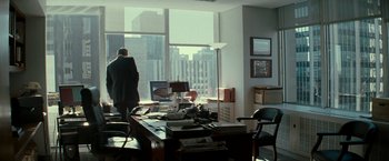 Movie still from “Michael Clayton” (2007), directed by Tony Gilroy – A man standing in front of a window in a room; Wide shot, Over the shoulder angle