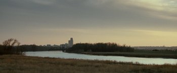 Movie still from “Michael Clayton” (2007), directed by Tony Gilroy – A view of a river with a bridge in the background; Extreme Wide shot, High angle