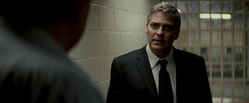 Movie still from “Michael Clayton” (2007), directed by Tony Gilroy – A man wearing a suit and tie in front of a mirror; Close Up shot, Over the shoulder angle