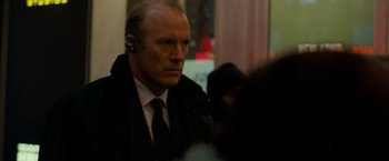 Movie still from “Michael Clayton” (2007), directed by Tony Gilroy – A man wearing a suit and tie with a headset; Close Up shot, Over the shoulder angle