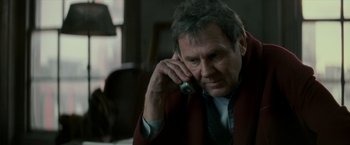 Movie still from “Michael Clayton” (2007), directed by Tony Gilroy – An older man talking on a cell phone while sitting at a table; Close Up shot, High angle