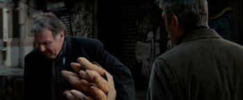 Movie still from “Michael Clayton” (2007), directed by Tony Gilroy – A person holding a bunch of food in their hands; Close Up shot, Over the shoulder angle