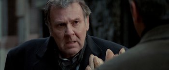 Movie still from “Michael Clayton” (2007), directed by Tony Gilroy – An older man is holding a bunch of bread; Close Up shot, Over the shoulder angle