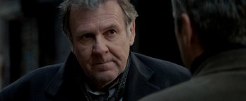 Movie still from “Michael Clayton” (2007), directed by Tony Gilroy – An older man wearing a suit and tie; Close Up shot, Over the shoulder angle