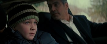 Movie still from “Michael Clayton” (2007), directed by Tony Gilroy – A man and a boy sitting in the back of a car; Close Up shot, Over the shoulder angle