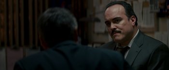 Movie still from “Michael Clayton” (2007), directed by Tony Gilroy – A man in a suit and tie talking to another man in a suit and tie; Close Up shot, Over the shoulder angle