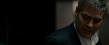 Movie still from “Michael Clayton” (2007), directed by Tony Gilroy – A person wearing a suit and tie; Close Up shot, Over the shoulder angle