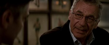 Movie still from “Michael Clayton” (2007), directed by Tony Gilroy – An older man wearing glasses and a suit; Close Up shot, Over the shoulder angle