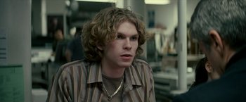 Movie still from “Michael Clayton” (2007), directed by Tony Gilroy – A man with long curly hair wearing a striped shirt; Close Up shot, Over the shoulder angle