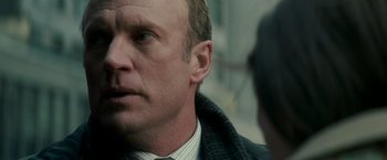 Movie still from “Michael Clayton” (2007), directed by Tony Gilroy – A person wearing a suit and tie; Close Up shot, Over the shoulder angle