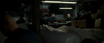 Movie still from “Michael Clayton” (2007), directed by Tony Gilroy – A group of men sitting at a table in a room; Medium shot, Over the shoulder angle