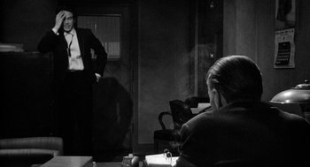 Movie still from “Mickey One” (1965), directed by Arthur Penn – A man standing in front of a woman in front of a mirror; Medium shot, Over the shoulder angle