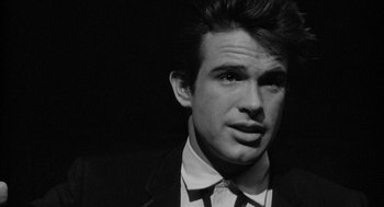 Movie still from “Mickey One” (1965), directed by Arthur Penn – Black and white photograph of a man in a suit; Close Up shot, Over the shoulder angle
