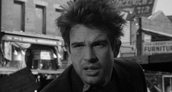 Movie still from “Mickey One” (1965), directed by Arthur Penn – Black and white photograph of a man with spiky hair; Close Up shot, Low angle