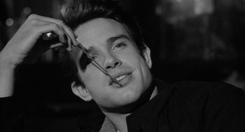 Movie still from “Mickey One” (1965), directed by Arthur Penn – A man with scissors cutting a man's hair; Close Up shot, Over the shoulder angle