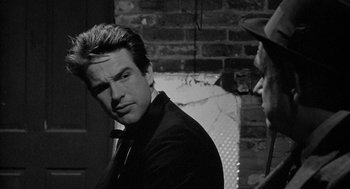 Movie still from “Mickey One” (1965), directed by Arthur Penn – A black and white photo of a man in a suit; Close Up shot, Over the shoulder angle