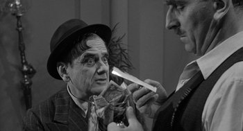 Movie still from “Mickey One” (1965), directed by Arthur Penn – A man in a hat is putting a knife on another man's face; Close Up shot, Over the shoulder angle