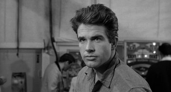 Movie still from “Mickey One” (1965), directed by Arthur Penn – Black and white photograph of a man in a suit and tie; Close Up shot, Low angle